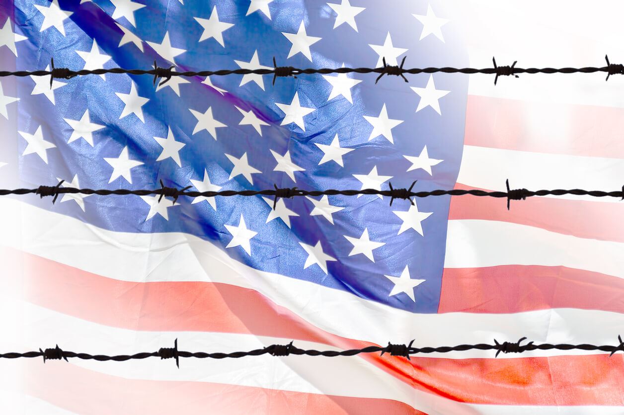 u.s flag behind barbed wire