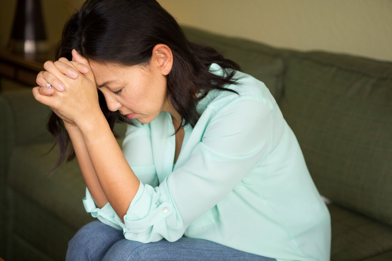 worried woman sitting on couch