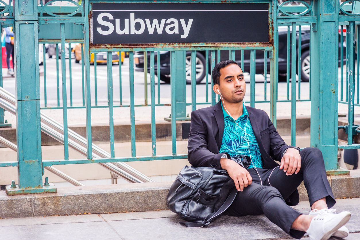 man sitting outside by the subway stairs