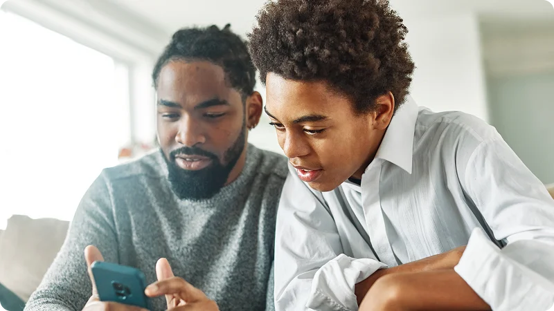 Two people looking at a smartphone together.
