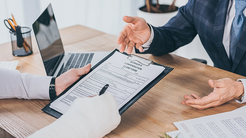 A worker with broken arm signing form for compensation claim.