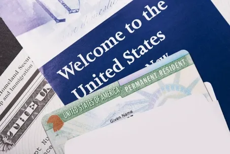 A U.S. Permanent Resident Card partially inside a white envelope.