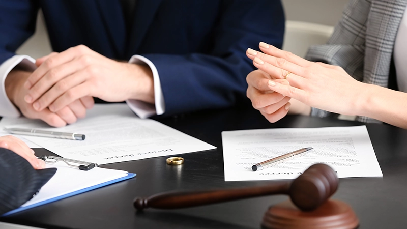 Young couple taking off wedding rings in lawyer's office.