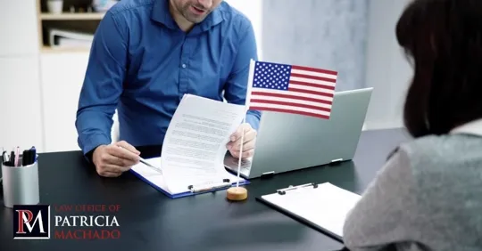 Legal professional reviewing documents with a client at a desk with a small U.S. flag.
